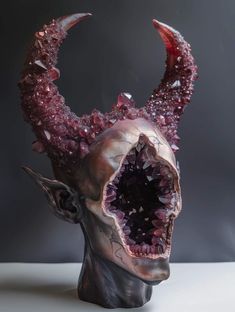 a sculpture of a demon's head with its mouth open and blood on it