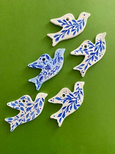 four blue and white ceramic birds on a green surface