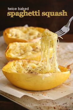 spaghetti being scooped out of an uncooked squash dish with a fork in it