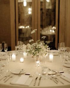 the table is set with white flowers and candles