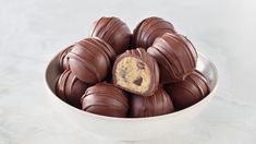 a white bowl filled with chocolate covered cookies