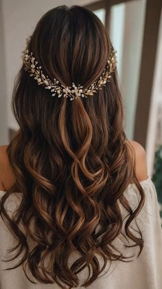 a woman with long brown hair wearing a gold headpiece