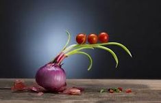 an onion and three cherry tomatoes on a wooden table