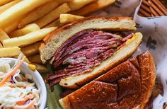 a corned beef sandwich with coleslaw and french fries