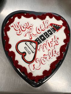 a heart shaped cake with the words you rock my guitar on it's side