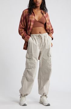 Drawstring-cinched cuffs create a baggy parachute effect in Y2K-inspired cargo pants cut from comfortable cotton and topped with an adjustable waistband. Elastic/drawstring waist Front slant pockets; back hook-and-loop flap-patch pockets; cargo hook-and-loop flap-bellows pockets Drawstring cuffs 100% cotton Machine wash, tumble dry Imported Not available for sale and shipment to Germany Khaki Cargo Pants Outfit Street Style, Tan Parachute Pants Outfit, Baggy Cargo Pants Outfit Woman, Baggy Cargo Pants Outfit, Gorpcore Fashion, Parachute Pants Outfit, Baggy Sweats, Cargo Pants Outfit Women, Cotton Cargo Pants