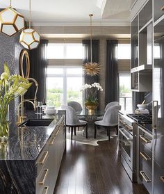 an elegant kitchen with marble counter tops and stainless steel appliances, along with gold accents