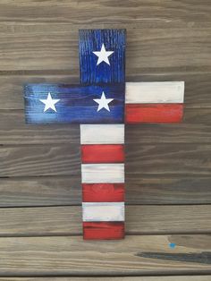 a wooden cross painted in the colors of the american flag