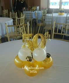 a table topped with balloons and gold decorations