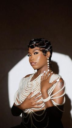 a woman in pearls and black dress posing for the camera