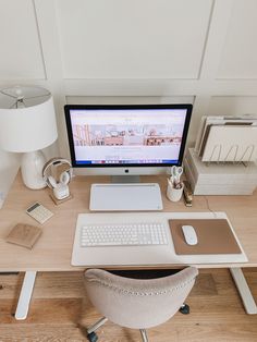 an office desk with a computer, keyboard and mouse on it in front of a lamp