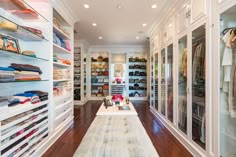 a large walk in closet with lots of shoes and handbags on the shelfs