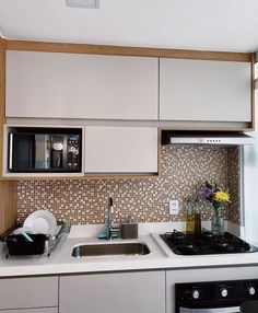 a kitchen with a sink, stove and microwave