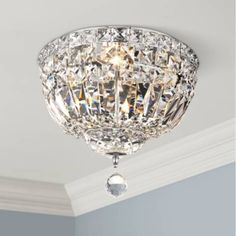 a crystal ceiling light hanging from the ceiling in a room with white walls and trimmings