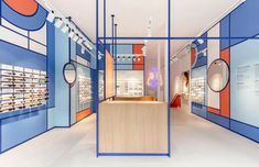 the inside of a store with blue, orange and white walls on both sides of it