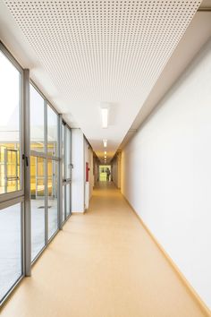 an empty hallway with lots of windows and white walls