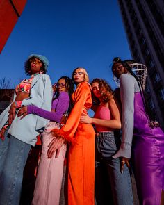 several women standing together in front of a tall building