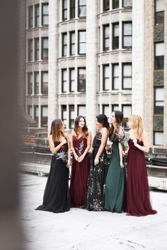 four women standing in front of a tall building