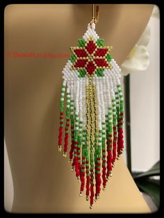 a close up of a mannequin with beads on it's head and a red flower in the center