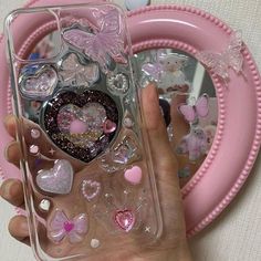 a person holding a phone case with hearts and butterflies on it in front of a heart shaped plate