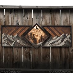 two paintings on wood with mountains and trees in the center, one is framed by a wooden fence