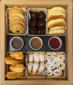 an open box filled with lots of different types of pastries and desserts next to each other