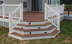 a deck with white railings and birds painted on the steps next to an open door