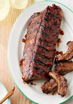 a piece of meat is sitting on a plate with sauce and fork next to it