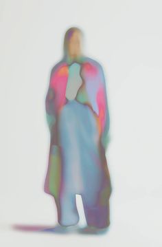 a blurry image of a man standing in front of a white background