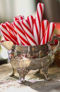 some candy canes in a silver cup on a table