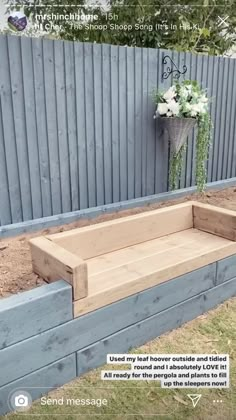 a planter box sitting in the middle of a yard next to a wooden fence