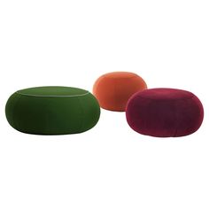 three different colored stools sitting next to each other on a white background, one is red and the other is green