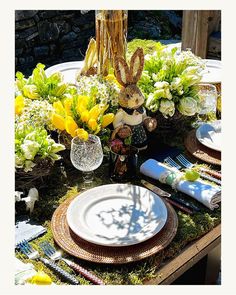 the table is set with plates and flowers