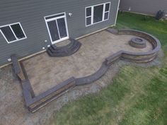 an outdoor patio with steps and firepit in the back yard, surrounded by grass