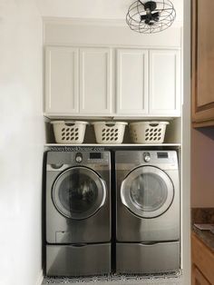 a washer and dryer in a laundry room with baskets on the top shelf