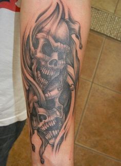 a man with a tattoo on his arm has a skull and roses tattooed on it