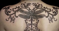 the back of a woman's neck with dragonflies on it