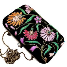 Turn heads wearing this colorful floral embroidered black velvet evening clutch bag. Be bright and bold! This exclusive design is expertly hand embroidered by master zardozi artisans. Each petal and leaf is outlined with glittery metallic gold threads and embellished with genuine semi precious stones, including garnets, turquoise, carnelian and onyx. Shop sustainably - own a handbag of exceptional quality that you will keep forever and pass down to the next generation. View more exclusive embroi Black Hand Embellished Party Clutch, Embroidered Evening Clutch For Festivals, Evening Embroidered Clutch For Festivals, Evening Clutch With Embroidery For Festivals, Festive Floral Embroidery Evening Bag For Party, Traditional Black Clutch For Evening, Traditional Black Clutch For Evening Events, Traditional Black Evening Clutch, Festive Floral Embroidery Evening Bag