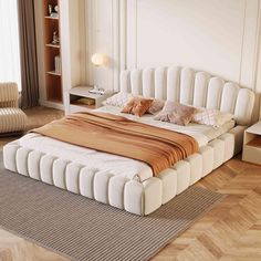 a large bed sitting on top of a hard wood floor next to a book shelf