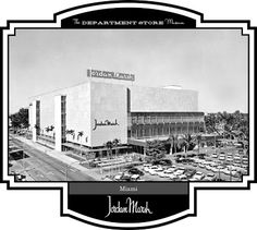 an old black and white photo of a building with cars parked in front of it