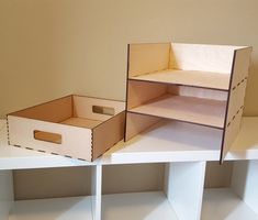 two cardboard boxes sitting on top of white shelves