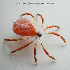 an orange and white spider sitting on top of a table