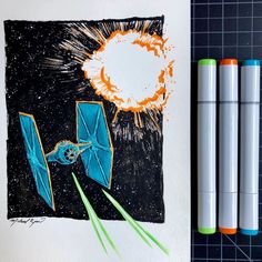 two markers are next to an image of a star wars tie - up and some pens