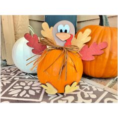 a turkey sitting on top of a pumpkin next to other pumpkins and gourds