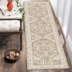 a large rug is on the floor next to a chair and vase with flowers in it