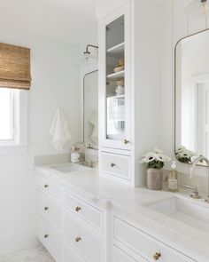 a white bathroom with two sinks and large mirrors on the wall above them is featured in this post