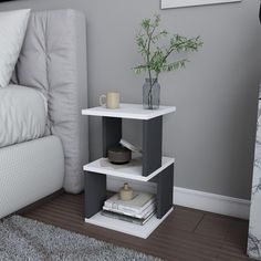 a corner table with a plant and books on it in front of a white couch