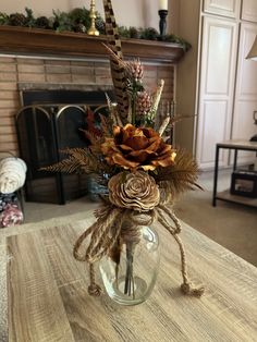 a vase filled with dried flowers on top of a table next to a fire place