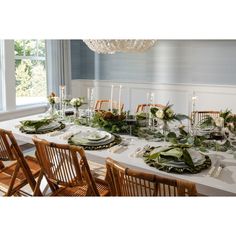 a dining room table is set with plates and place settings for an elegant dinner party