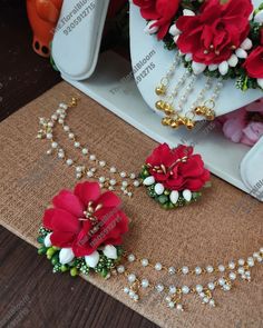 two necklaces with flowers and pearls are on the table next to other jewelry items